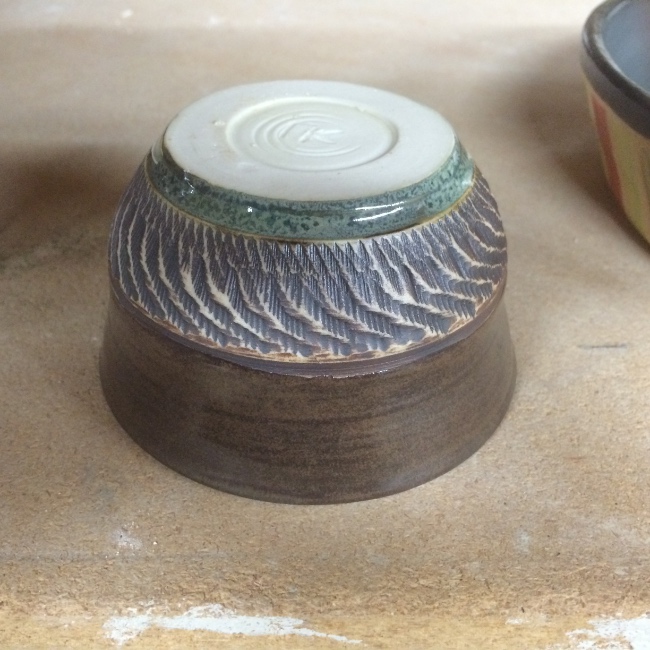 Textured tea bowl (inverted, emphasizing exterior texture), charcoal shino glaze, iron oxide, copper band highlight